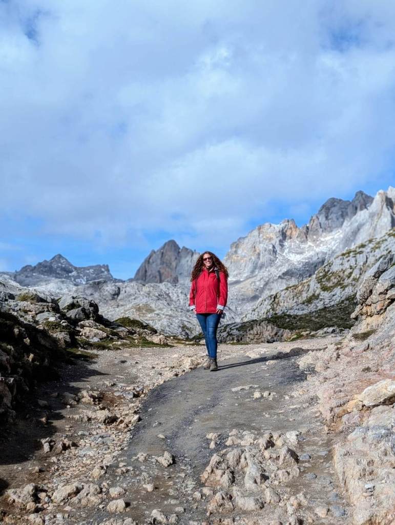 Mum standing with a stunning mountain backdrop in Picos de Europa, Spain.