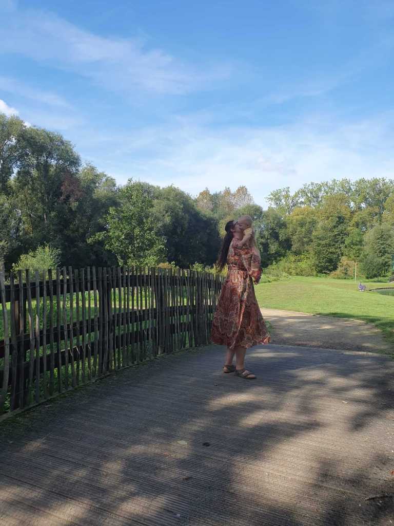 Mother dancing with her baby in a lush natural setting, capturing joyful, unscripted moments from slow family travel adventures