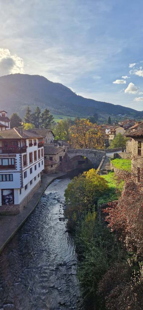 Scenic view of Potes town surrounded by lush hills, a perfect stop on a northern Spain road trip.