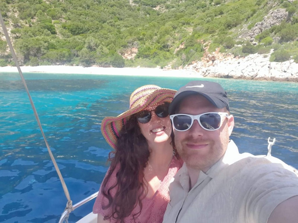 Smiling couple taking a selfie on a boat with blue sea in the background