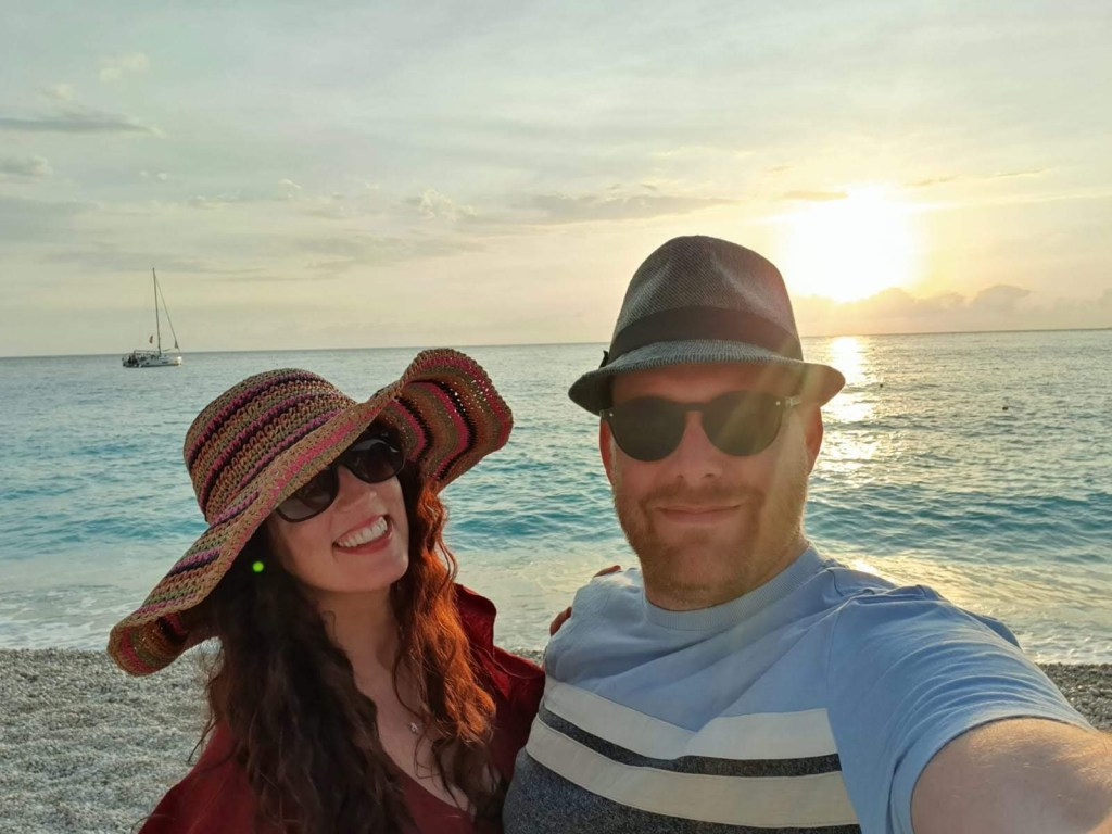 Couple taking a selfie with the sunset over Myrtos Beach in the background