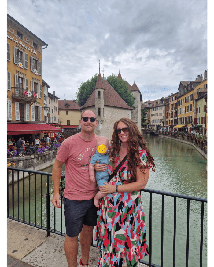 Family of three posing beside the canal in Annecy, France