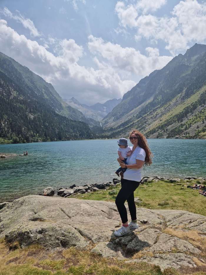 Mum and baby by a glacier lake in the Pyrenees, surrounded by mountain stillness