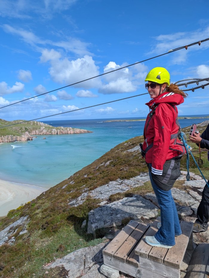 Woman preparing to ride the zip line across Ceannabeinne Beach