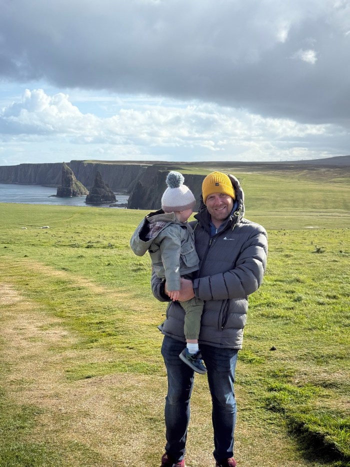 Man and toddler overlooking Duncansby Stacks in northern Scotland