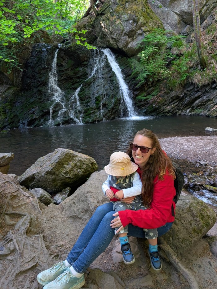 Woman and toddler by the Fairy Glen waterfall in Scotland