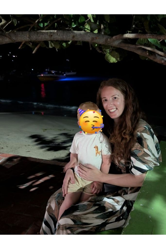 Mother and child sitting by the beach near Gros Islet during the Friday Night Street Party