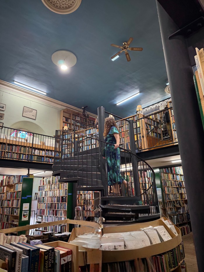 Woman browsing second-hand books inside Leakey’s Bookshop in Inverness