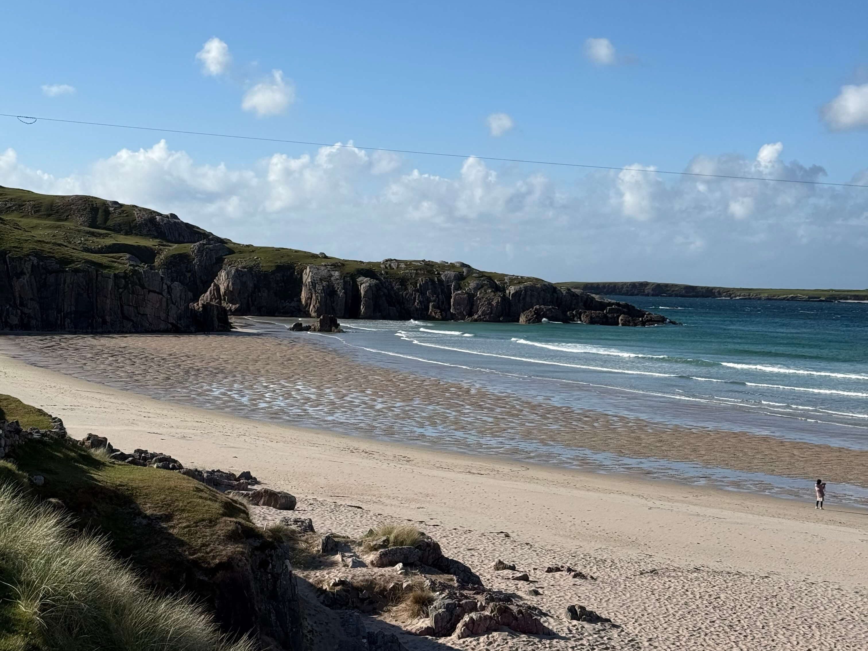 Wide view of a remote Scottish beach with turquoise water and golden sand