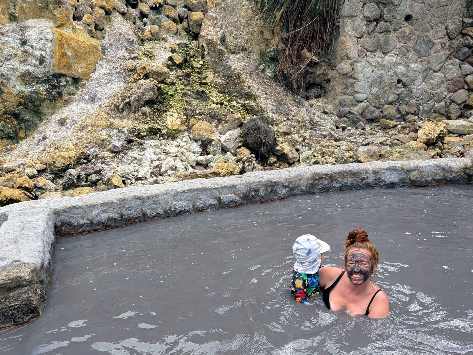 Mum and toddler soaking in the mud pools at Saint Lucia’s Sulphur Springs