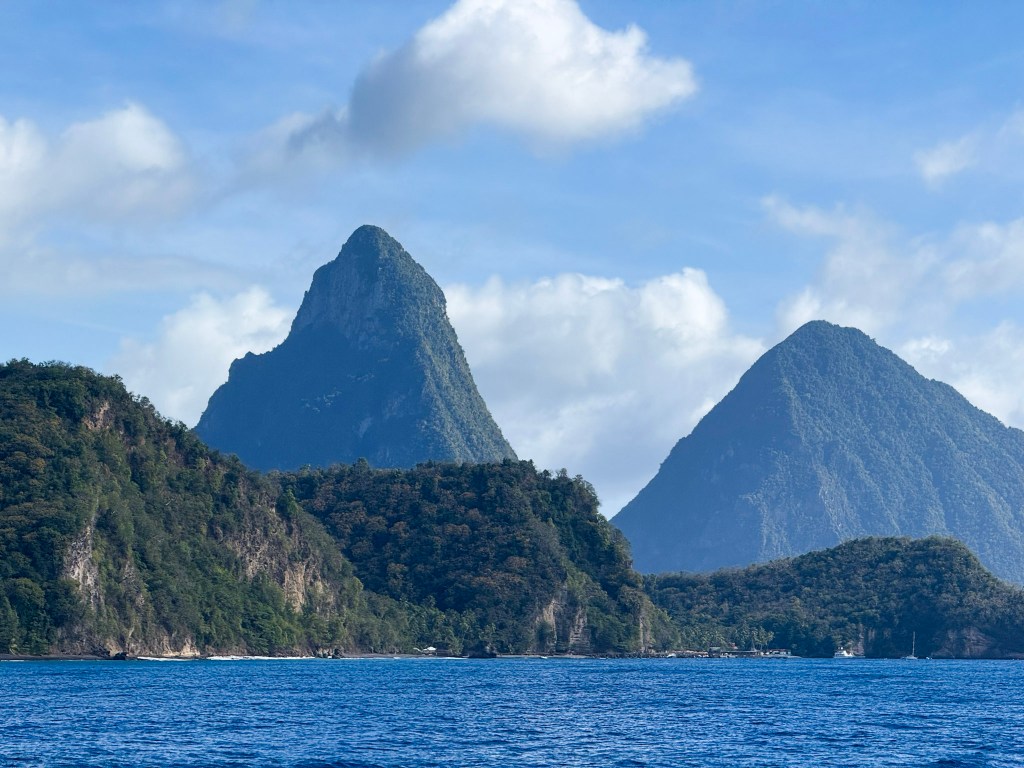 The Pitons seen from our sunset cruise View of the Pitons rising from the sea on a Carnival Sailing sunset cruise in Saint Lucia