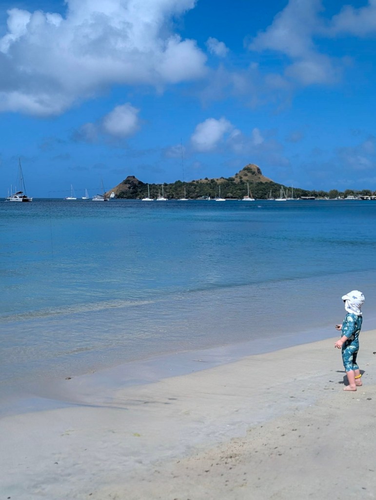 Child standing on Gros Islet Beach in Saint Lucia looking out over the Caribbean Sea