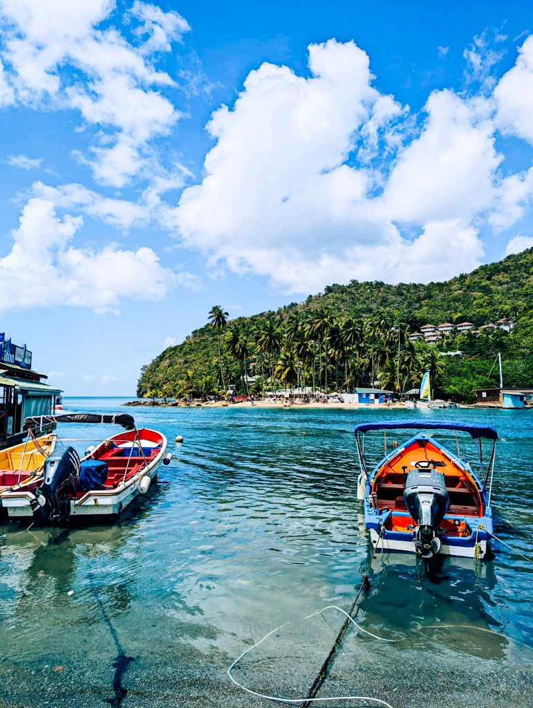 Boats anchored in Marigot Bay, Saint Lucia, with the small sheltered beach in the distance