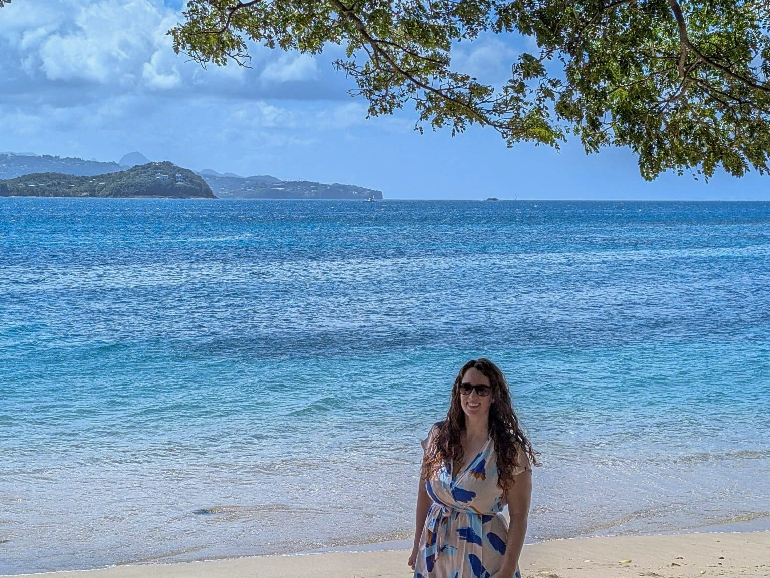 Woman standing on Pigeon Island Beach in Saint Lucia with the Caribbean Sea behind