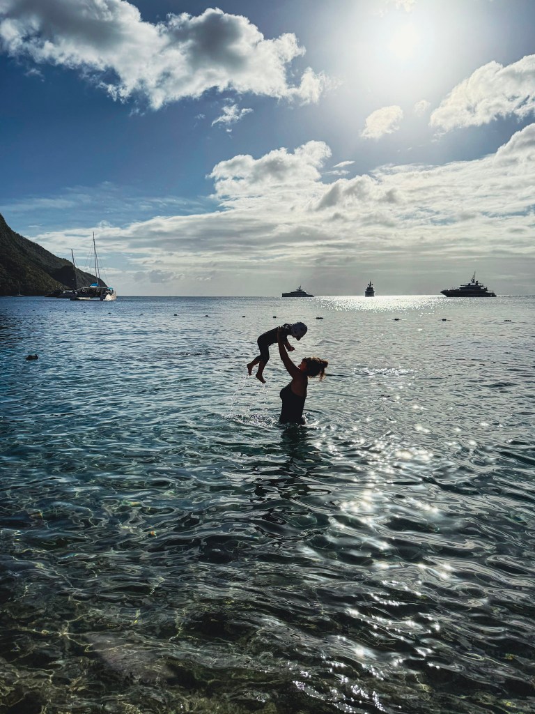 Mother and child playing in the clear Caribbean waters at Sugar Beach, Saint Lucia