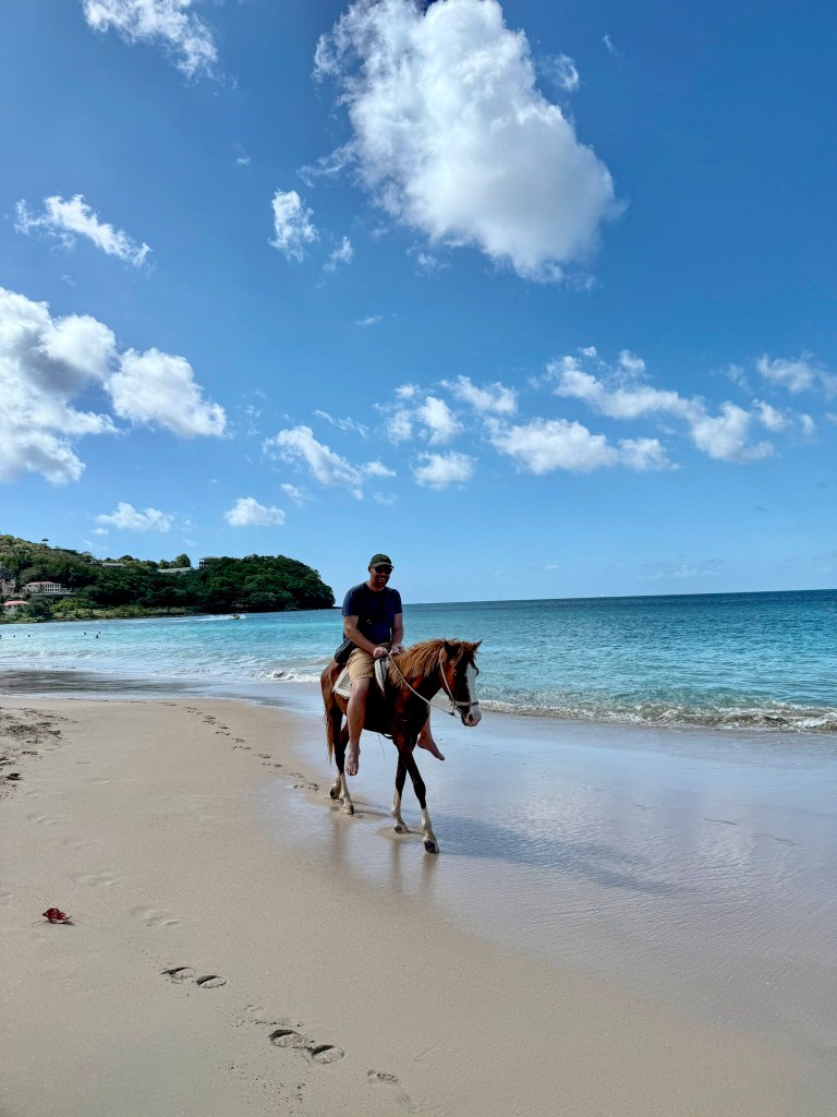 Man riding a horse along the shoreline at Vigie Beach in Saint Lucia