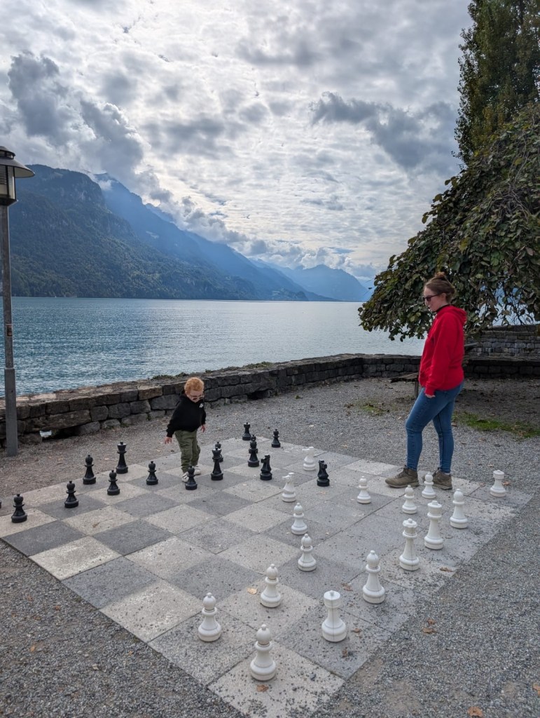 Mother and toddler playing giant chess outdoors in Brienz, Switzerland.