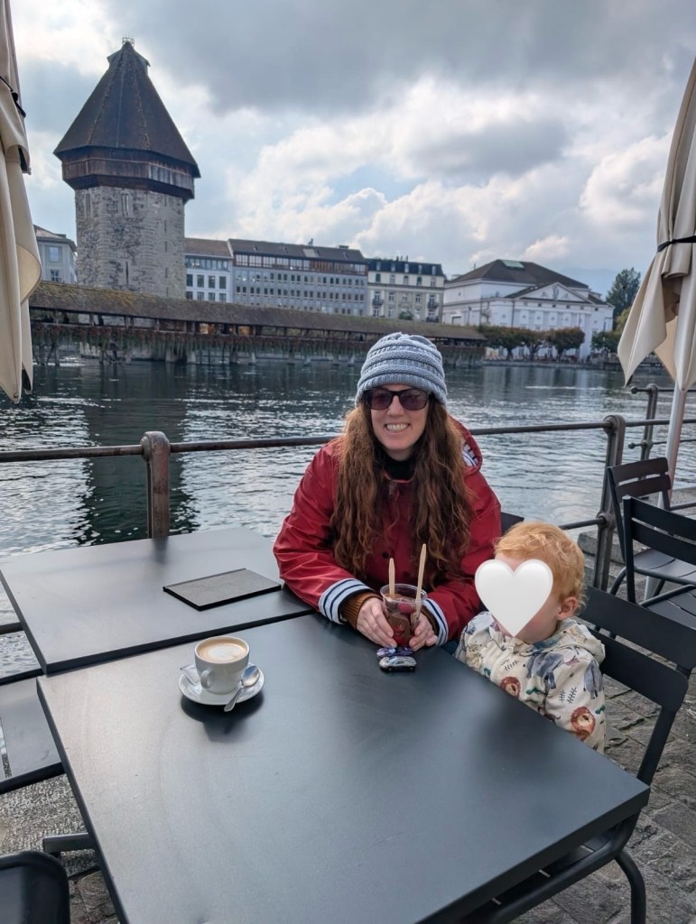 Mother and child eating chocolate-covered strawberries with Lake Lucerne in the background